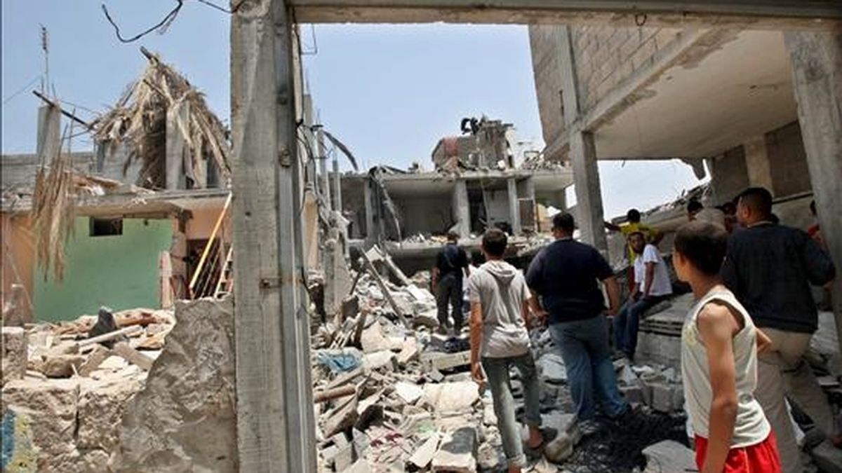 Varios palestinos observan los daños en sus viviendas tras una explosión registrada el lunes, en la casa de un líder de Hamás en el centro de la franja de Gaza. EFE/Archivo