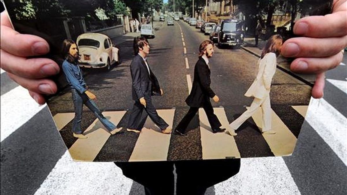 Un guía turístico sostiene una copia del disco "Abbey Road", de los Beatles, en esta calle de Londres, Reino Unido. EFE/Archivo