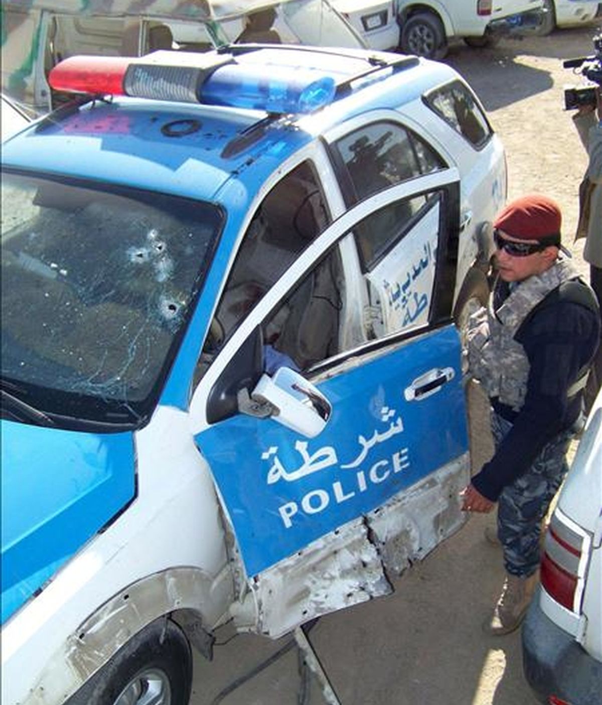 Un policía iraquí inspecciona los daños registrados en un vehículo policial tras la explosión de una bomba en el centro de Basora, al sur de Irak, el pasado 29 de diciembre. EFE/Archivo