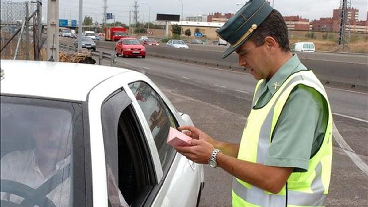 Un guardia civil observa el carnet de un conductor en un control de tráfico en Madrid. EFE/Archivo