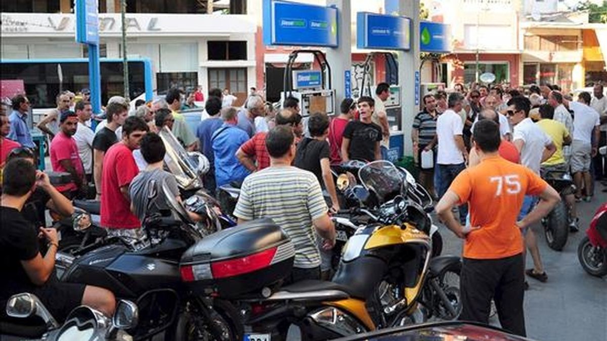 Griegos hacen cola en una gasolinera para llenar de combustible algunas garrafas, en Atenas, durante una huelga de transportes. EFE/Archivo