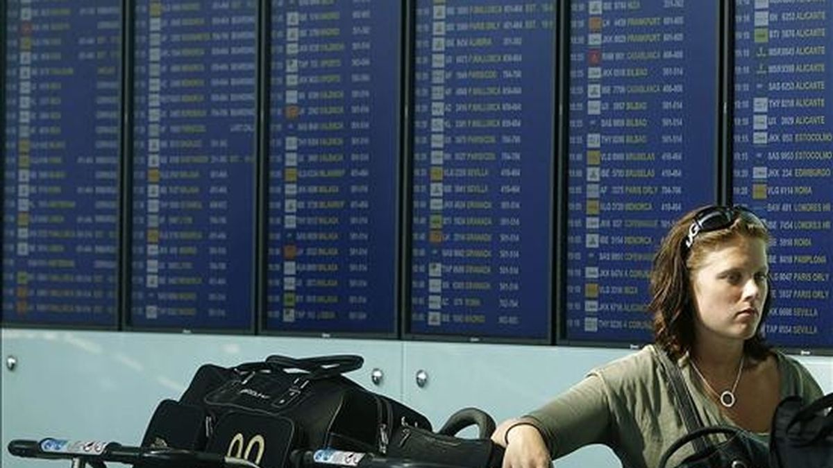 Una pasajera ante un panel de información de la Terminal 1 del aeropuerto de El Prat en una jornada en la que faltaron 39 controladores aéreos del Centro de Control de Tráfico Aéreo de Gavà (Barcelona). EFE/Archivo