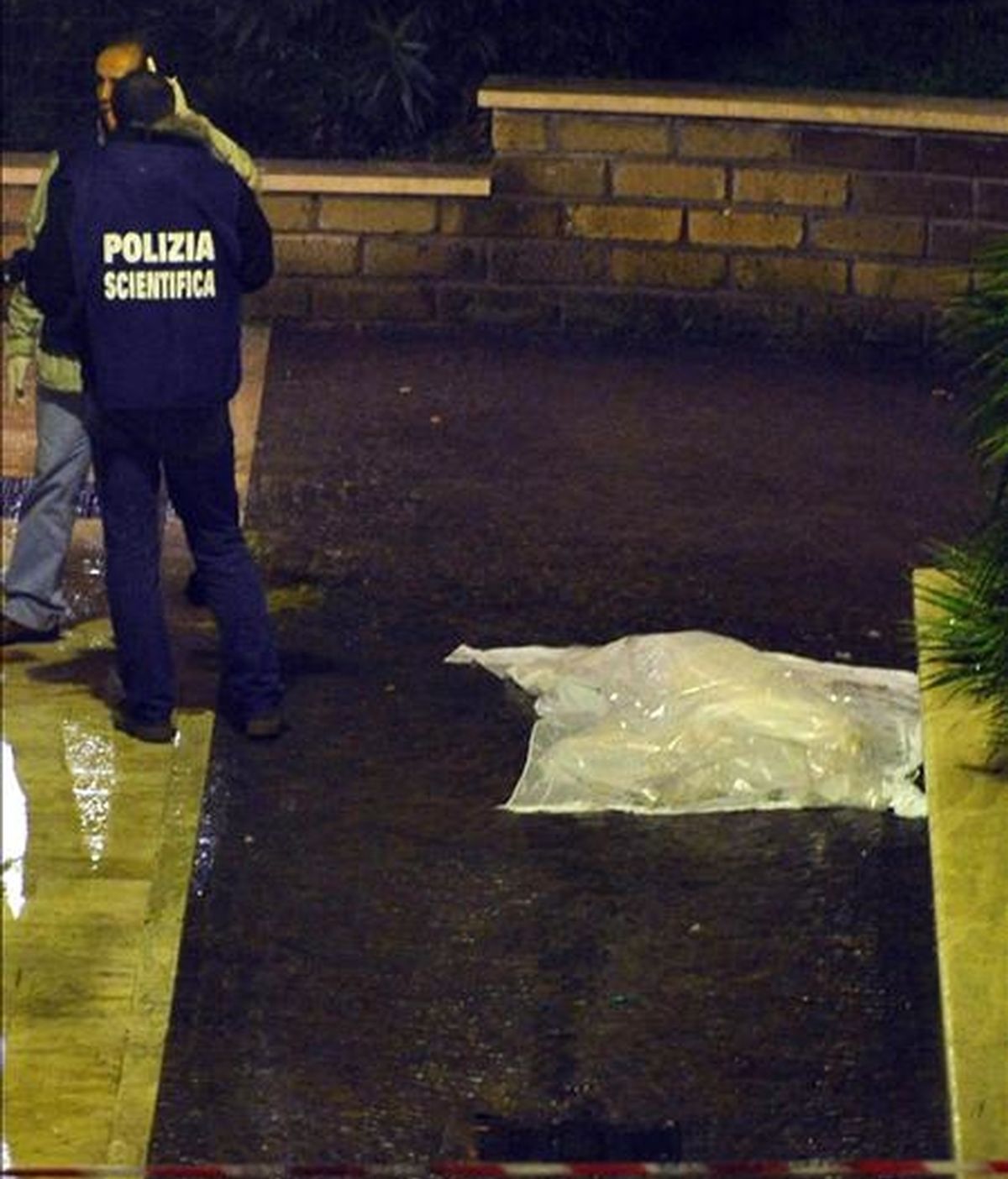 Policías forenses cubren el cuerpo sin vida del director y guionista italiano Mario Monicelli (d), quien se suicidó a sus 95 años de edad al lanzarse por una ventana del hospital San Giovanni. EFE