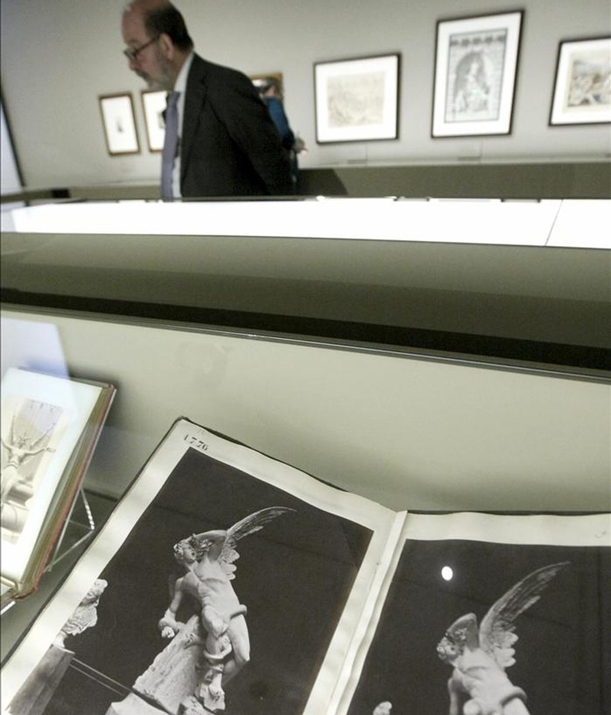 En primer plano, dos fotografías de Laurent & Cía de la escultura "El Ángel caído", de Ricardo Bellver (que se encuentra en la glorieta del mismo nombre del madrileño parque de El Retiro), que forma parte de las piezas de la exposición "No solo Goya ", organizada por el Museo del Prado. EFE