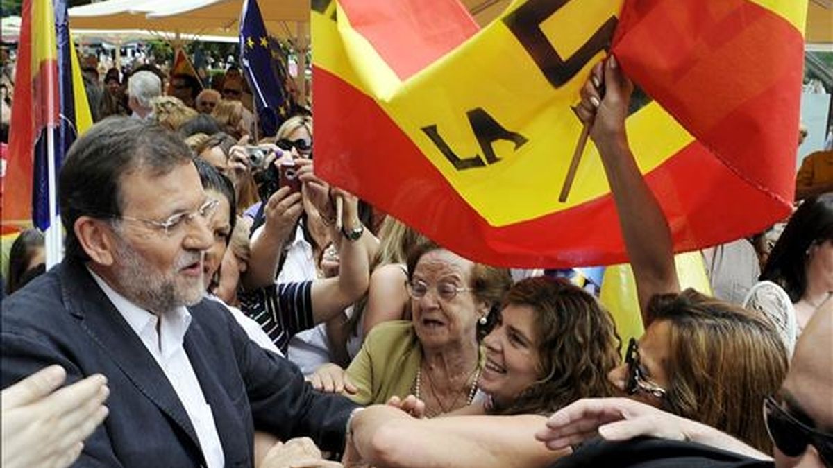 El presidente del PP, Mariano Rajoy (i), saluda a los simpatizantes, durante el encuentro que ha mantenido, hoy en la plaza del Altozano de Albacete, con motivo de los comicios europeos del próximo domingo. EFE