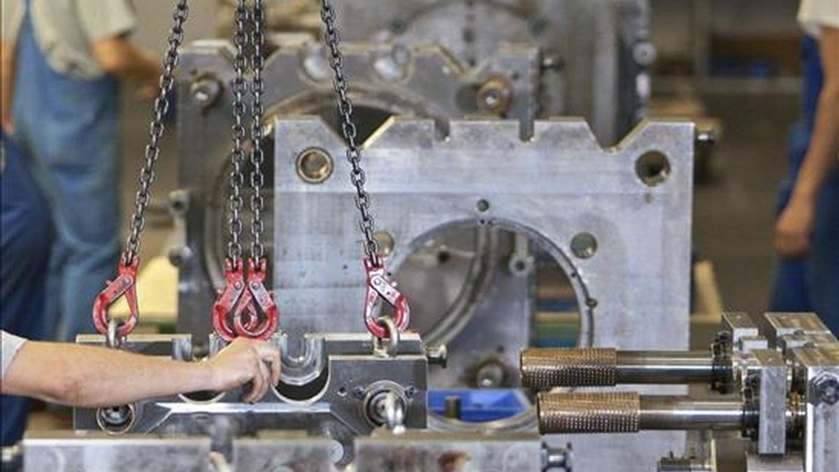 Empleados de una fábrica de automóviles trabajan en una cadena de montaje. EFE/Archivo