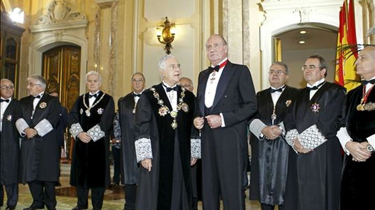 El rey Juan Carlos atiende al presidente del Consejo General del Poder Judicial, Carlos Dívar, a su llegada al solemne acto de apertura de los tribunales que da inicio al nuevo Año Judicial. EFE