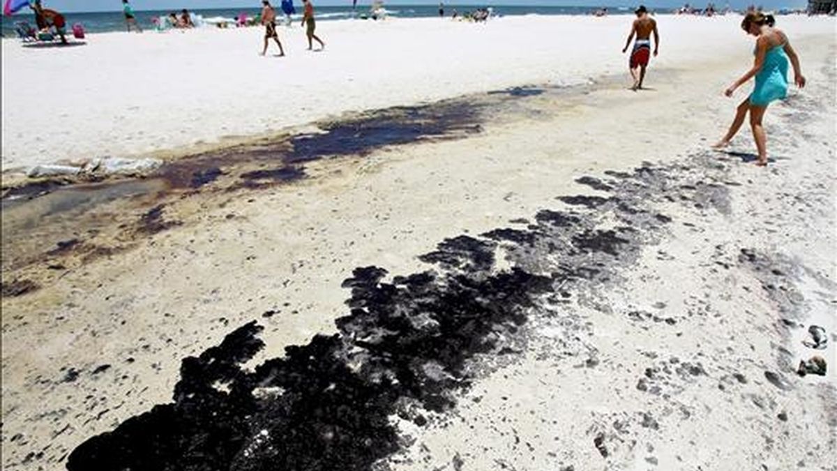 Fotografía del pasado 4 de julio en la que se registró a varias personas que intentaban esquivar las manchas de petróleo en una playa de Gulf Shores, Alabama. La marea negra llegó este mates al también sureño estado de Texas, Estados Unidos. EFE/Archivo