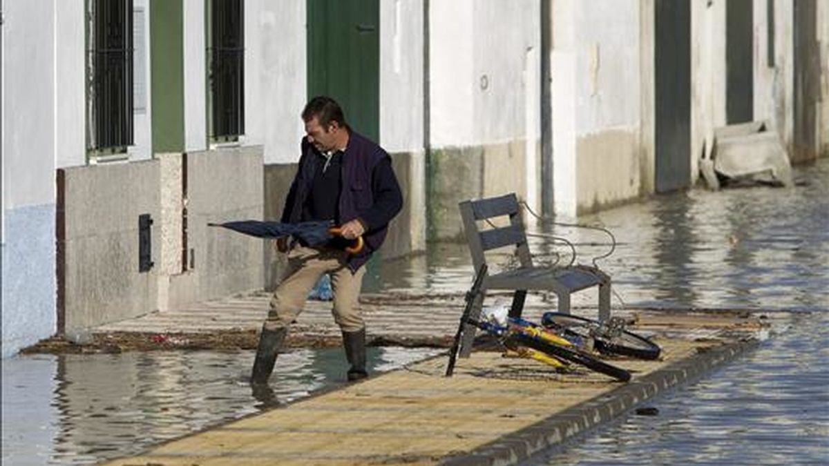 Un vecino de la localidad sevillana de Tocina intenta acceder a su vivienda que permanece inundada desde ayer por la crecida del río Guadalquivir, provocada por las intensas precipitaciones de los últimos días. EFE