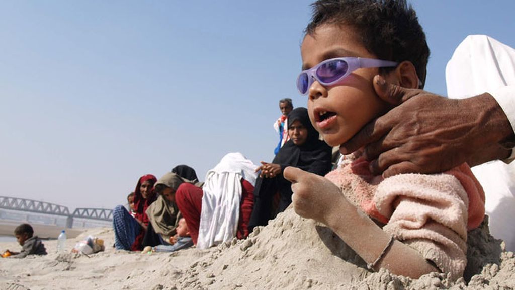 Entierran a sus hijo para ver el eclipse de sol en Pakistán