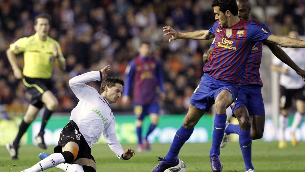 El delantero argentino del Valencia Pablo Piatti intenta robar el balón al centrocampista del Barcelona Sergio Busquets