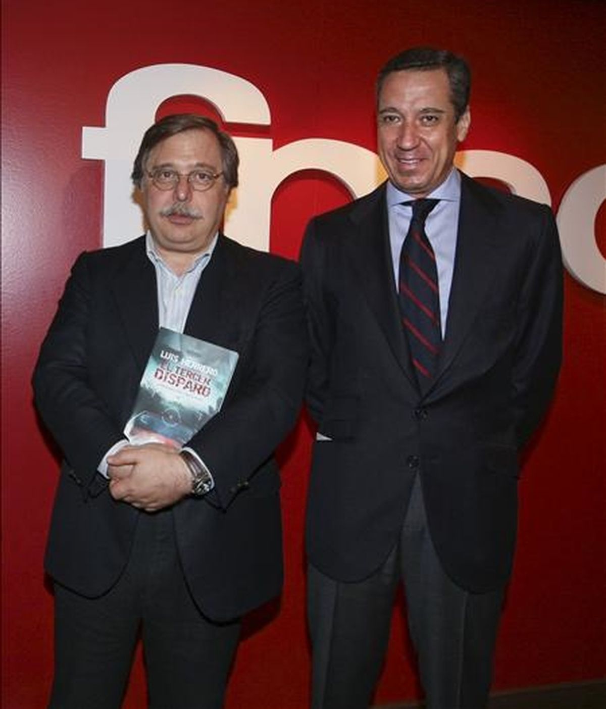 El eurodiputado del Partido Popular Luis Herrero,iz, acompañado por el ex portavoz parlamentario del PP Eduardo Zaplana,d, durante la presentación de su primera novela, "El tercer disparo". EFE