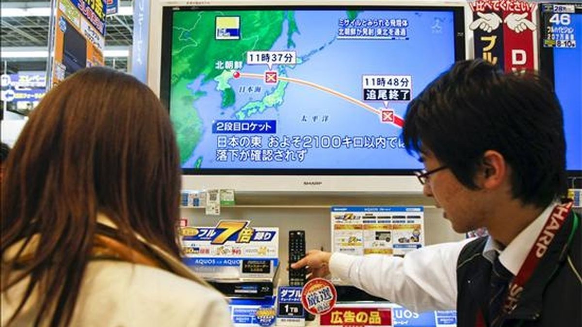 Clientes observan una pantalla de televisión que muestra un mapa con la trayectoria del satélite de comunicaciones norcoreano lanzado, en una tienda de electrónica en Seúl. EFE/Archivo