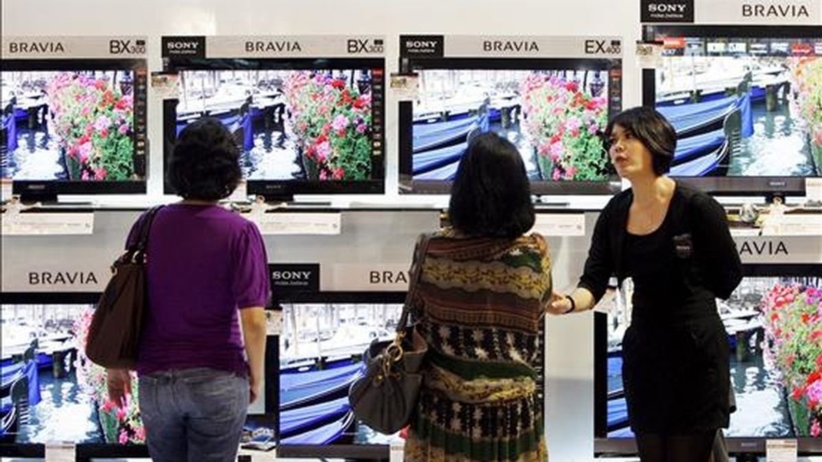 Dos mujeres escuchan una explicación sobre unas pantallas de televisión en una tienda. EFE/Archivo