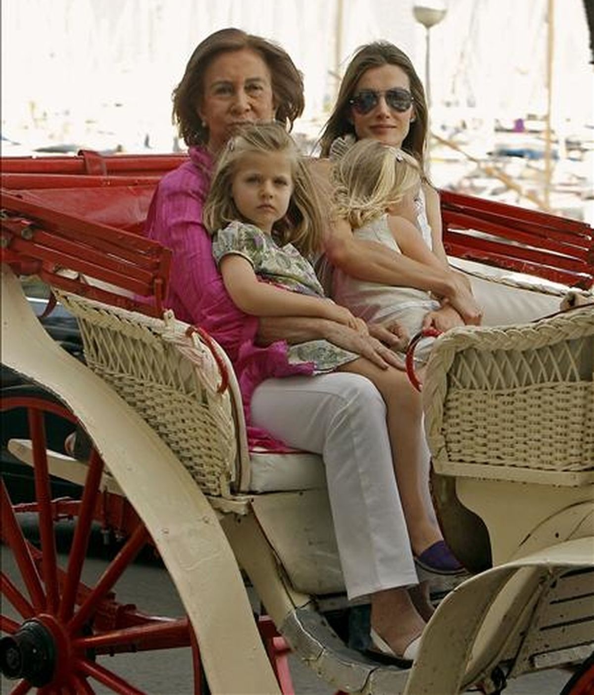 La Reina Sofía, acompañada por la princesa Letizia y las infantas Leonor y Sofía, durante el paseo en calesa que han realizado esta tarde por las calles de Palma de Mallorca. EFE