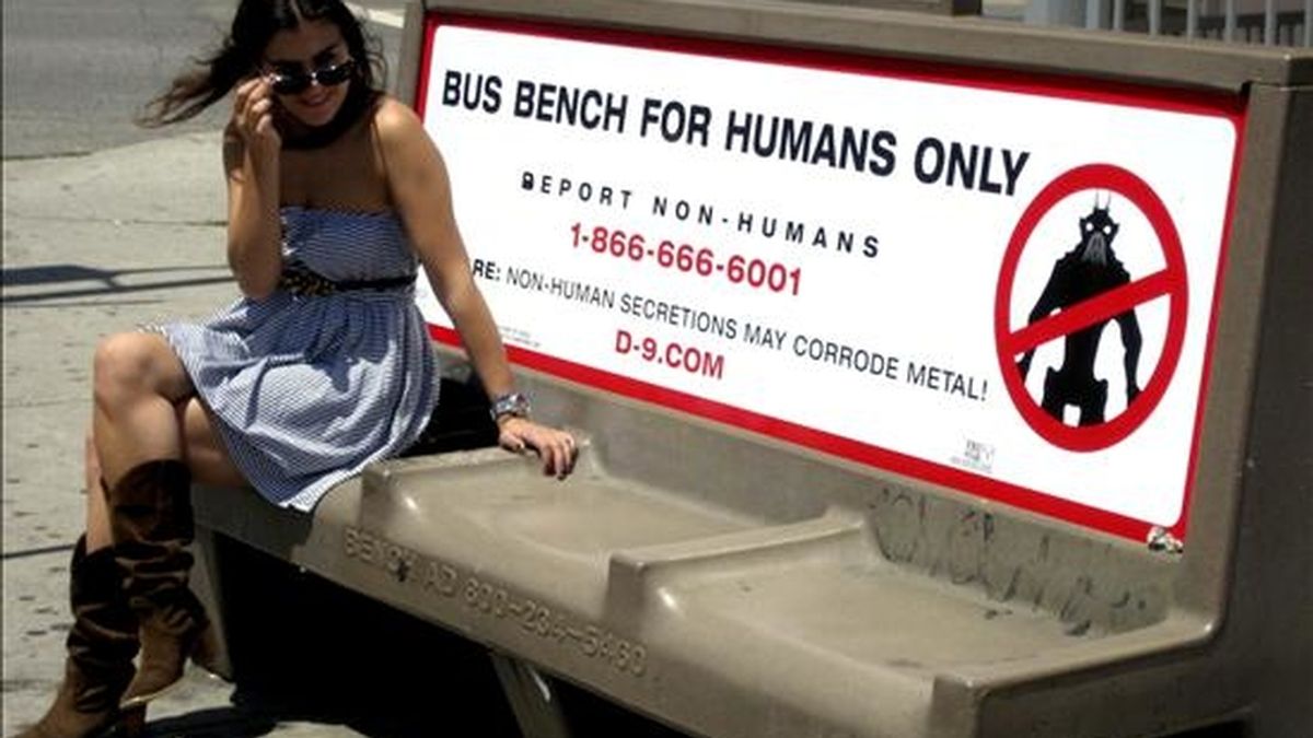 Una mujer permanece sentada junto a un letrero promocional de la película "District 9" que dice "Banca de bus sólo para humanos", en Los Ángeles. El anuncio hace parte de una campaña publicitaria para el filme. EFE