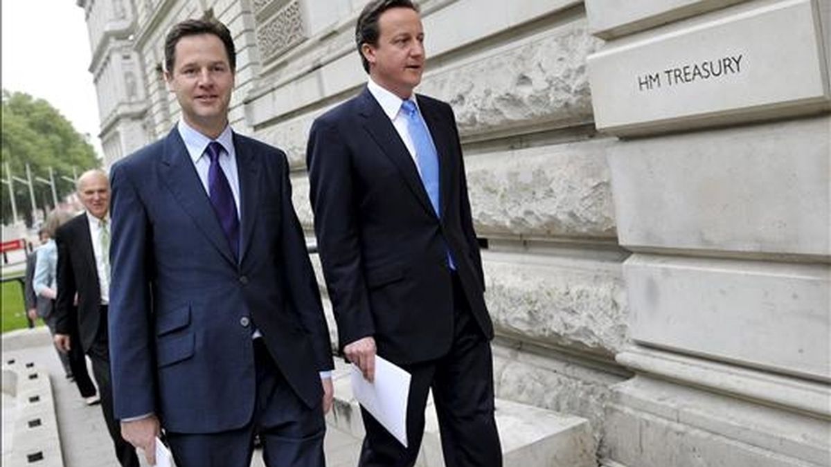 El primer ministro británico, David Cameron (d), conversa con el viceprimer ministro, Nick Clegg. EFE/Archivo