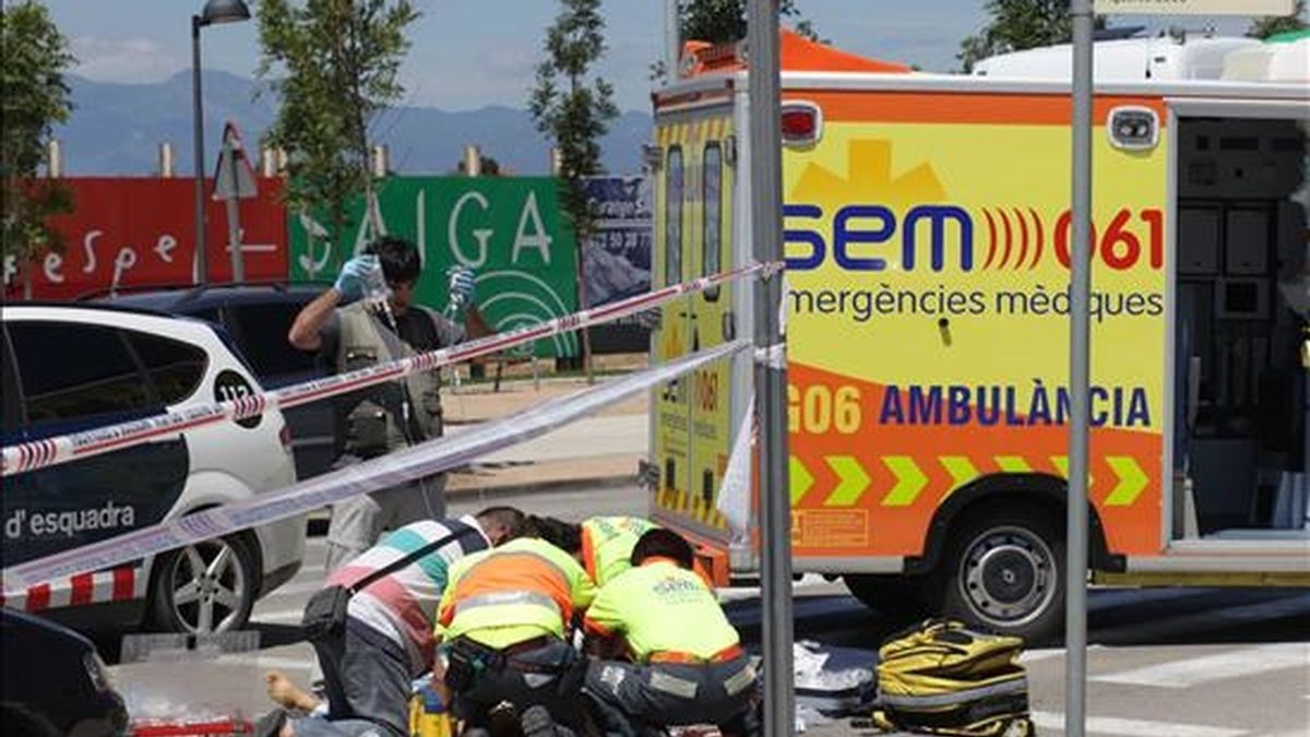 Miembros de los equipos de emergencia tratan de reanimar al conductor muerto por otro conductor este mediodía a la entrada de Figueres golpeándole con un gato de coche cuando discutían después de chocar los vehículos que conducían. EFE