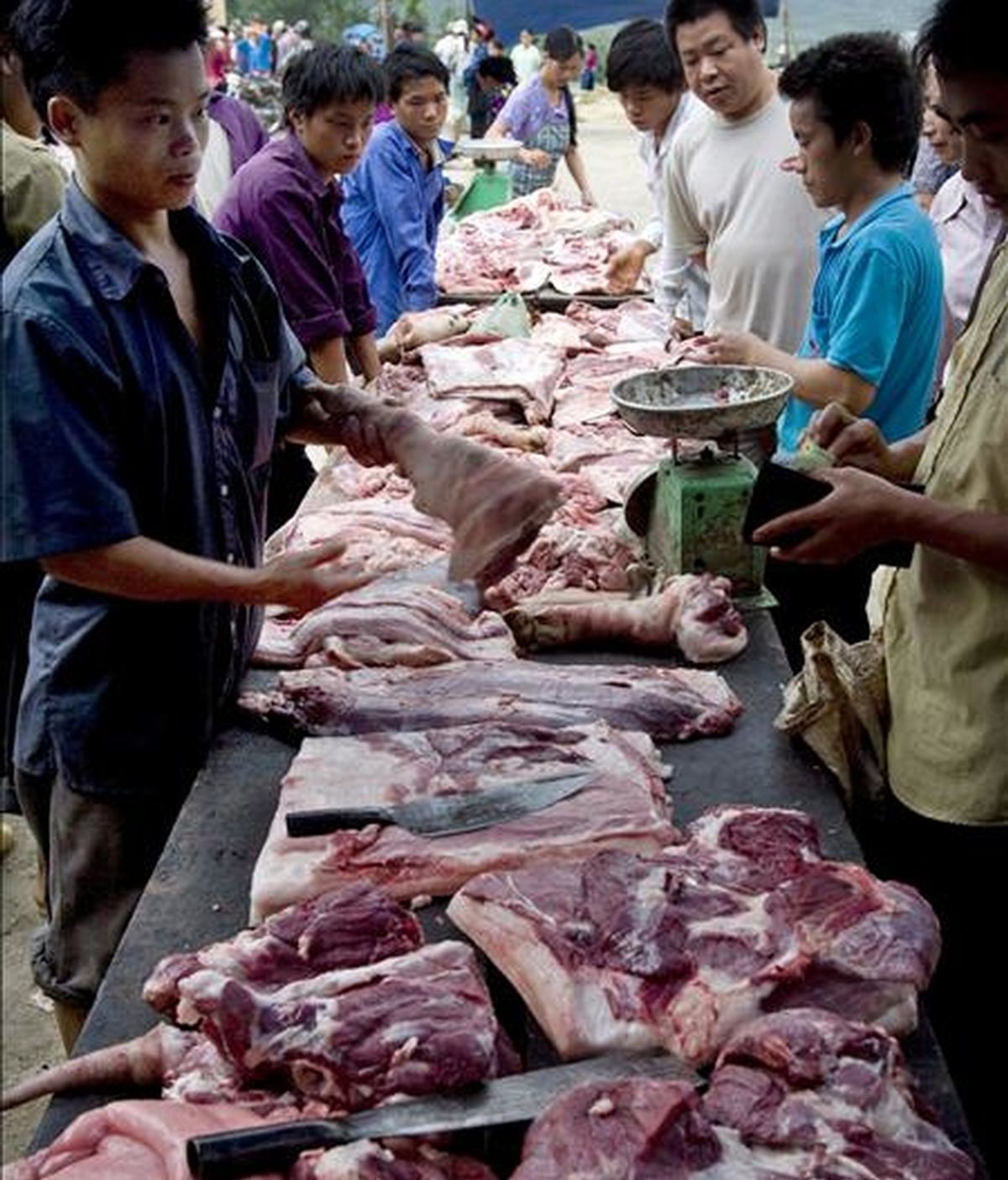 Varias personas comprando carne de cerdo en un mercado al aire libre de la provincia de Ha Giang, al norte de Vietnam. EFE/Archivo