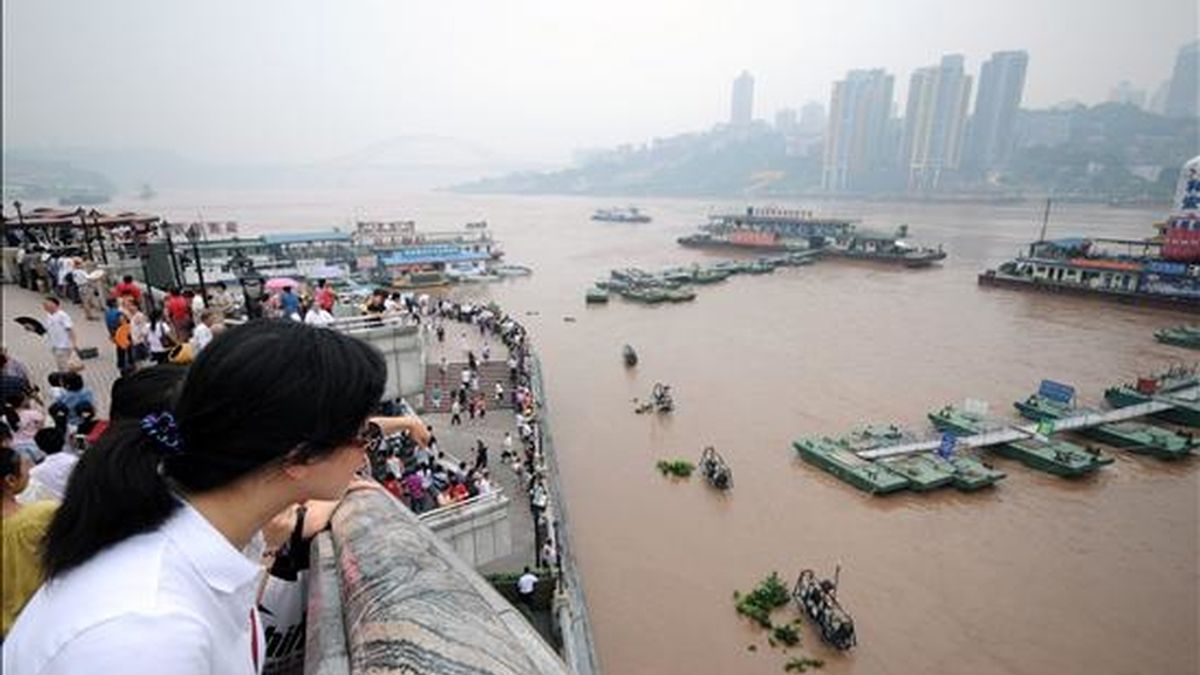 Fotografía tomada el lunes 19 de julio, en la que un grupo de habitantes de la ciudad de Chongqing, ubicada en el sureste de China, observa como sube el nivel del río Yangtze, el cual ha alcanzado su nivel más alto desde 1981. EFE/Archivo