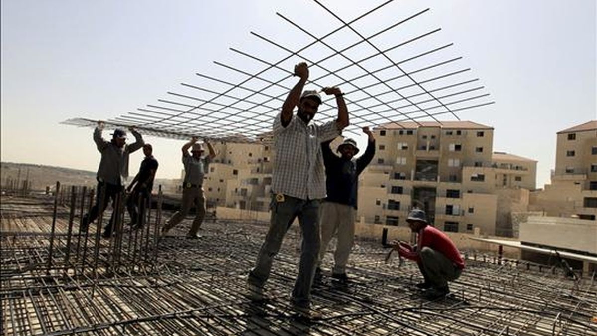 Obreros palestinos construyen el tejado de un edificio de viviendas en el asentamiento judio de Beitar Illit, Cisjordania, el pasado 10 de junio. EFE/Archivo