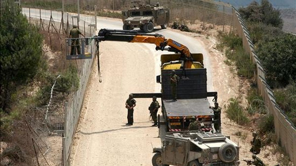 Soldados israelíes utilizando una grúa para cortar un árbol del lado libanés, en la localidad fronteriza de Adaisseh (Líbano) este martes. EFE