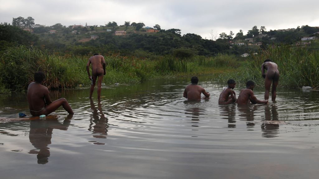 Un grupo de sudafricanos se baña en el río antes de peregrinar a la montaña Nhlangakazi