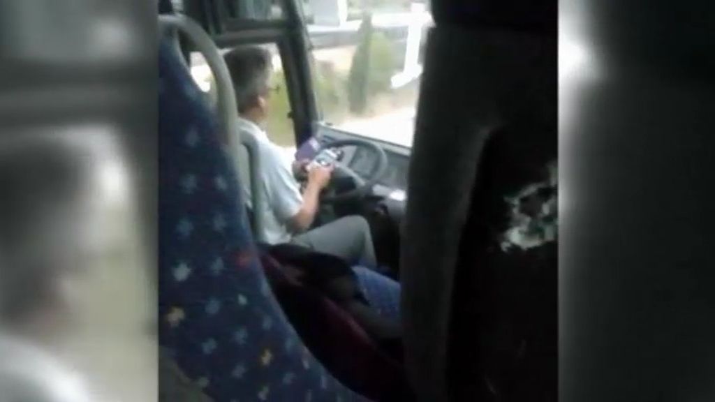 Graban a un conductor de autobús escolar manejando su móvil al volante
