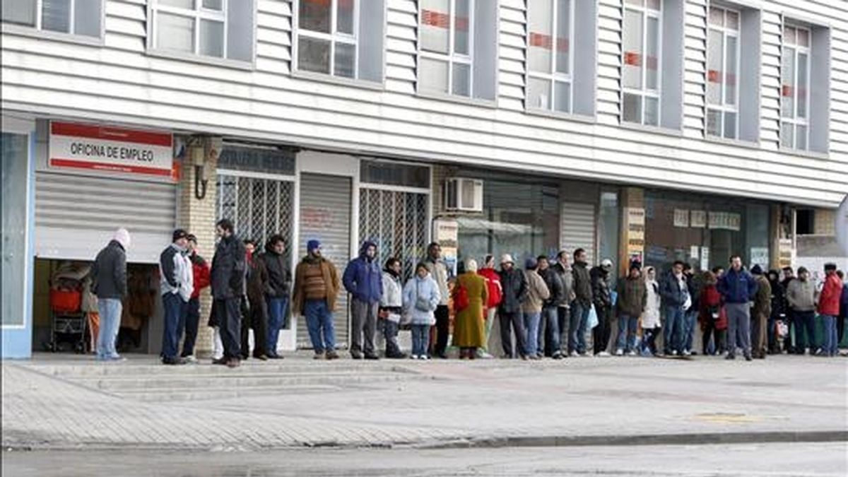 Varias personas forman una larga cola ante una oficina del INEM. EFE/Archivo