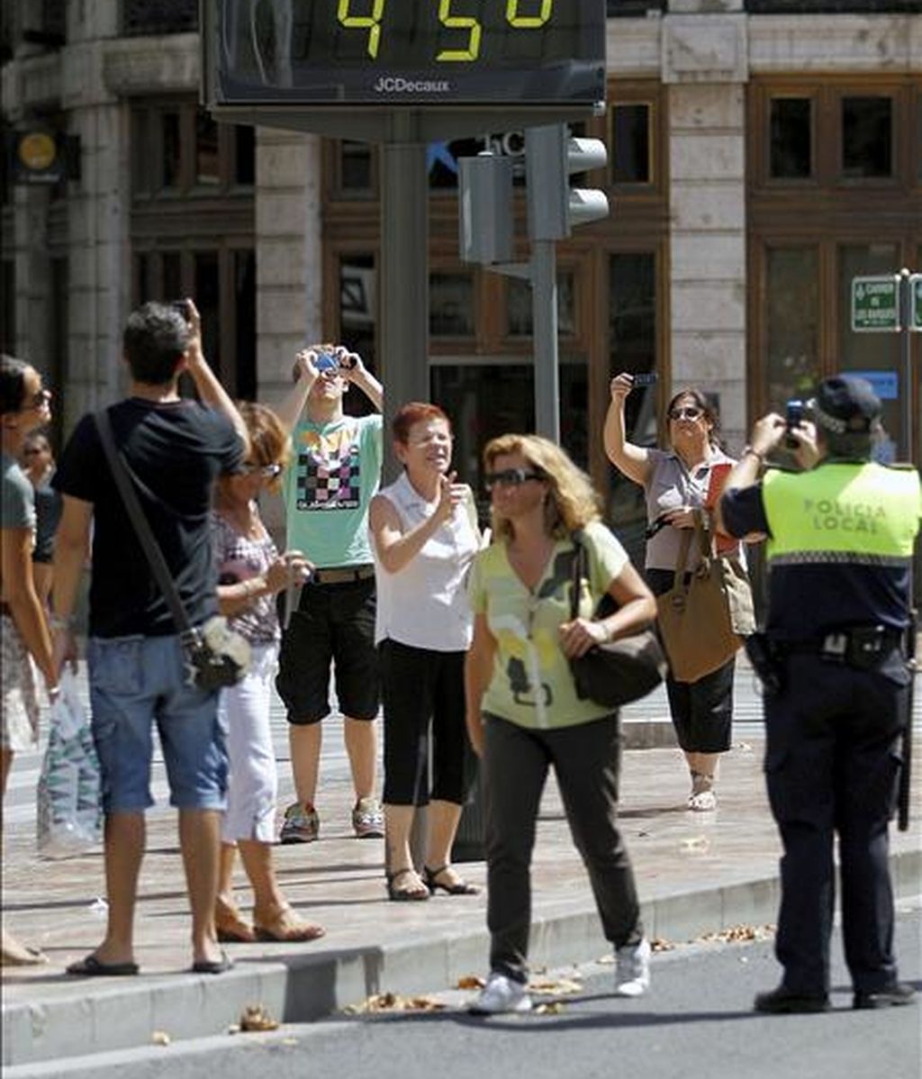 Un grupo de turistas y un policía local hacen fotos de un termómetro situado en el centro de la capital, que marca 45 grados. EFE/Archivo Un grupo de turistas y un policía local hacen fotos de un termómetro situado en el centro de la capital, que marca 45 grados. EFE/Archivo