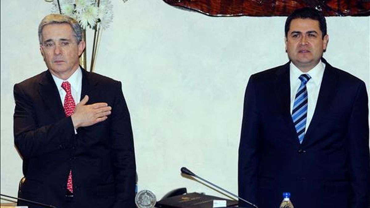 El ex presidente de Colombia, Álvaro Uribe (i), asiste, junto al presidente del Congreso de Honduras, Juan Orlando Hernández (d), a un acto en el que fue condecorado por esa institución en Tegucigalpa (Honduras). EFE