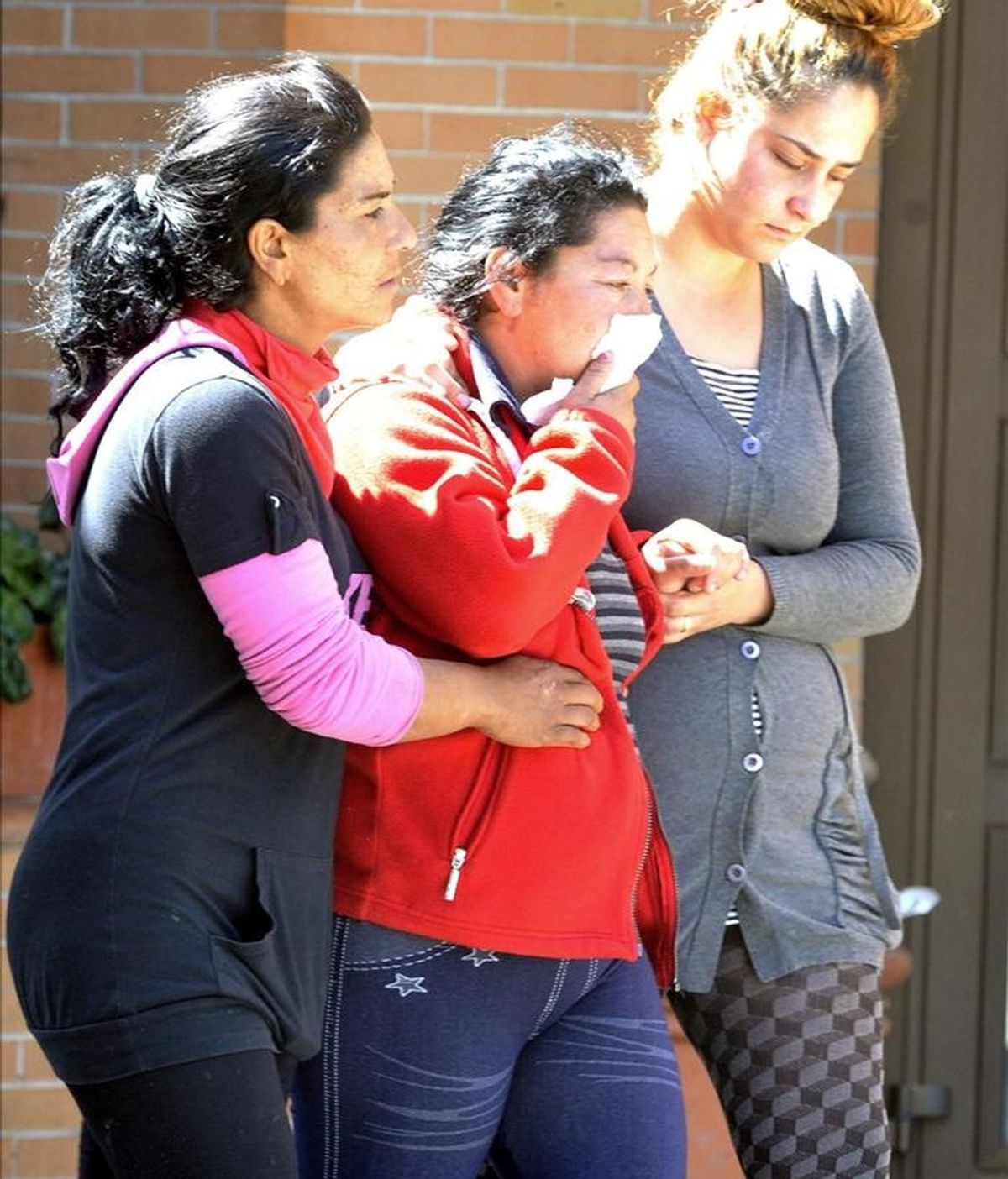 La madre del niño de seis años cuyo cadáver fue encontrado en la parte trasera de su edificio en Granada, tras caer desde el tercer piso de este bloque, es acompañada por familiares en el cementerio granadino de San José. EFE