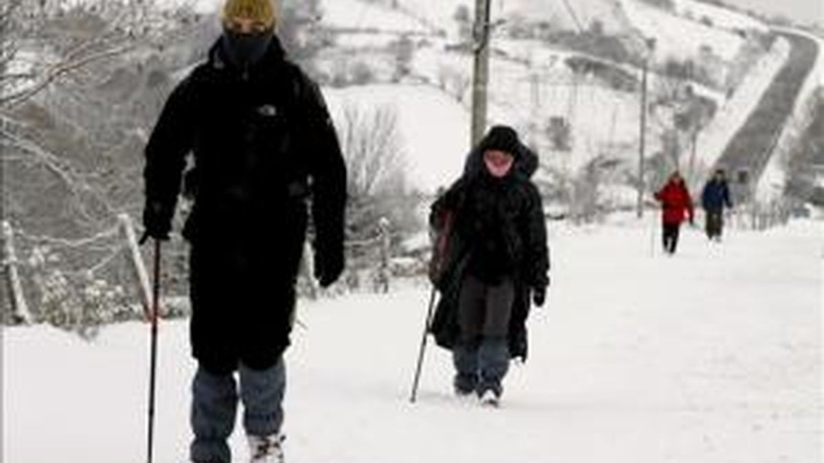 Un grupo de peregrinos camina esta mañana hacia Santiago de Compostela, junto a la carretera LU-633, en Pedrafita do Cebreiro, tras la intensa nevada de la pasada noche. EFE