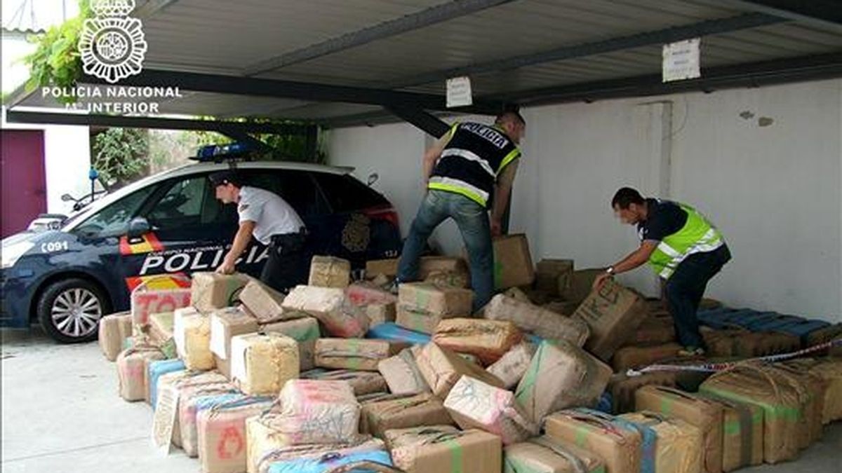 Tres policías nacionales comprueban el estado de los fardos con siete toneladas de hachís intervenidos el pasado mes de septiembre en Andalucía. EFE/Archivo
