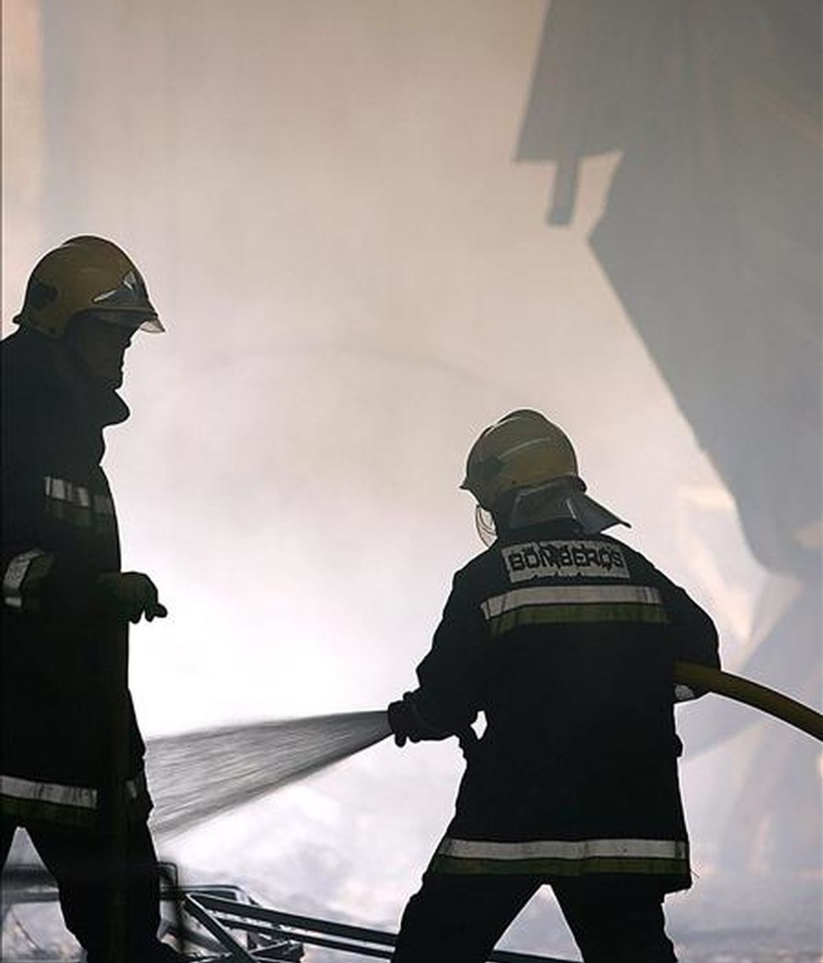 Varios bomberos trabajan en la extinción de un incendio en 2005 en el polígono Santa Cruz de la capital malagueña. EFE/Archivo