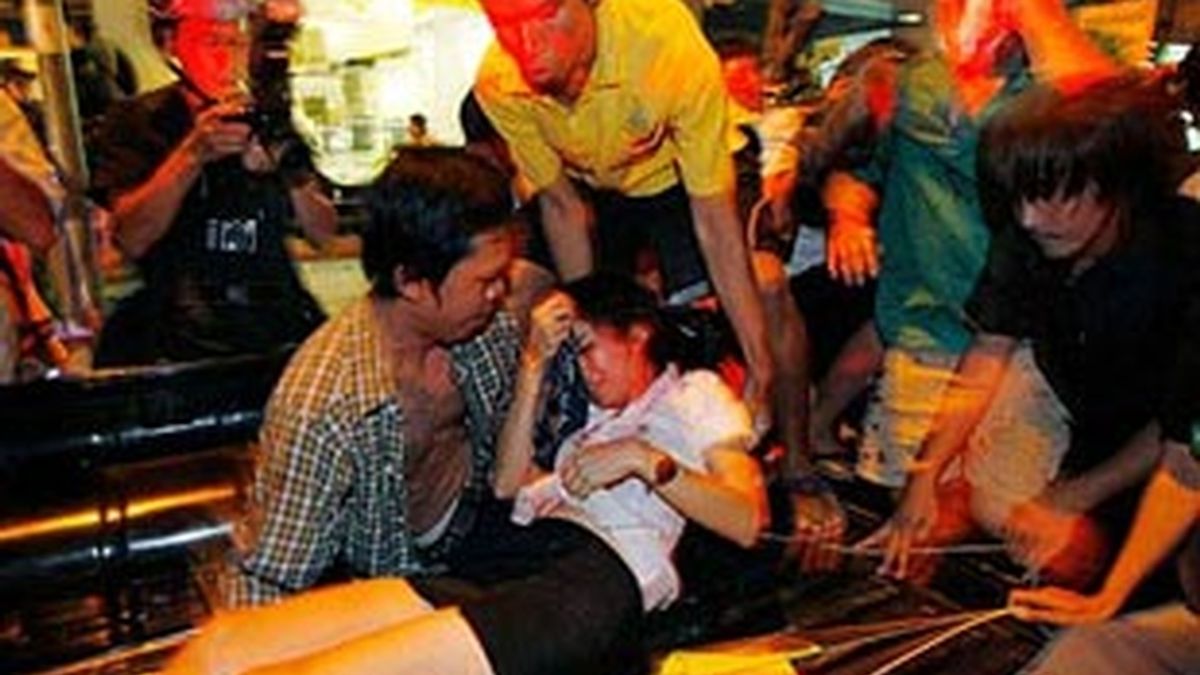 Varias personas atienden a una de las víctimas de las explosiones de Bangkok. Foto: AP