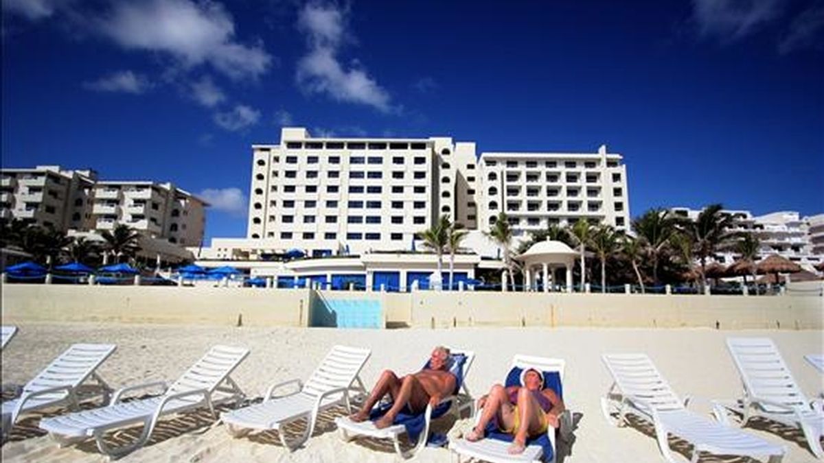 Turistas en una playa de Cancún, que acoge hasta el 10 de diciembre la conferencia de la ONU sobre Cambio Climático, y es paradigma de los efectos del calentamiento global y víctima de terribles huracanes que han dañado sus arrecifes coralinos y manglares. EFE