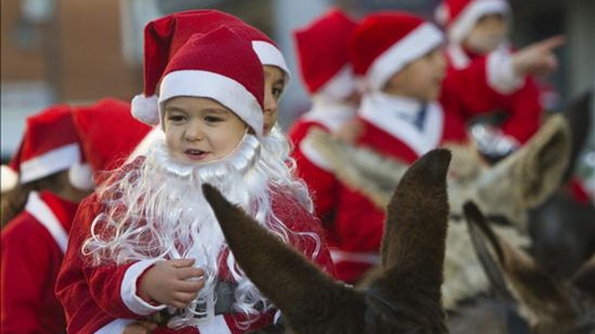 Niños de Moguer (Huelva) vestidos de Papa Noel y montados en burro recorrieron las calles del pueblo con motivo del aniversario del nacimiento de Juan Ramón Jiménez.EFE