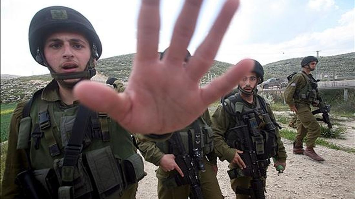 Soldados israelíes intentan impedir que se tomen fotografías de los enfrentamientos con palestinos participantes en una manifestación con motivo del Día de la Tierra en la localidad cisjordana de Idna. EFE
