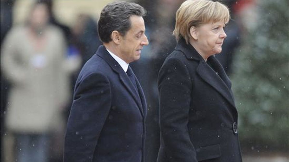 La canciller alemana, Angela Merkel (izda), y el presidente francés, Nicolas Sarkozy (dcha), inspeccionan la guardia de honor a su llegada hoy a Friburgo en Alemania. En el marco de las habituales Consultas Franco-alemanas, los dos dirigentes tratarán de estructurar una postura común en materia financiera de cara a la cumbre ordinaria de jefes de Estado y Gobierno de la Unión Europea (UE), según medios alemanes. EFE