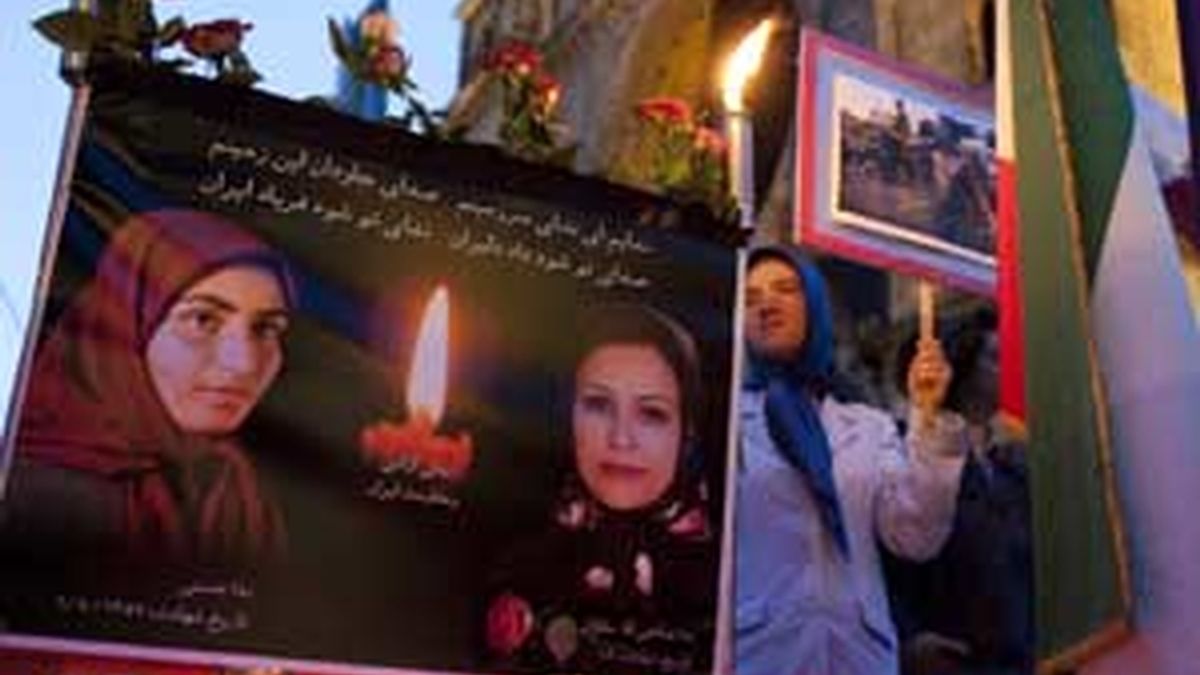 Una mujer de pie junto a las fotografías de varios víctimas iraníes durante una manifestación de apoyo a las protestas en Irán realizada en Berlín. Foto: REUTERS