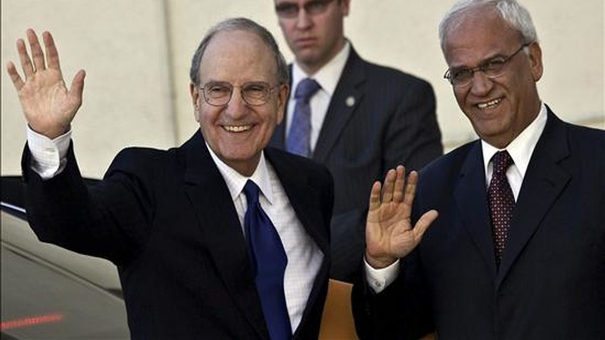 El enviado especial de EEUU para la paz en Oriente Medio, George Mitchell (i), y el negociador palestino Saeb Erekat (d), saludan a los periodistas tras el encuentro entre Mitchell y el presidente palestino, Mahmud Abás, en la ciudad cisjordana de Ramala, hoy martes 14 de diciembre de 2010. EFE