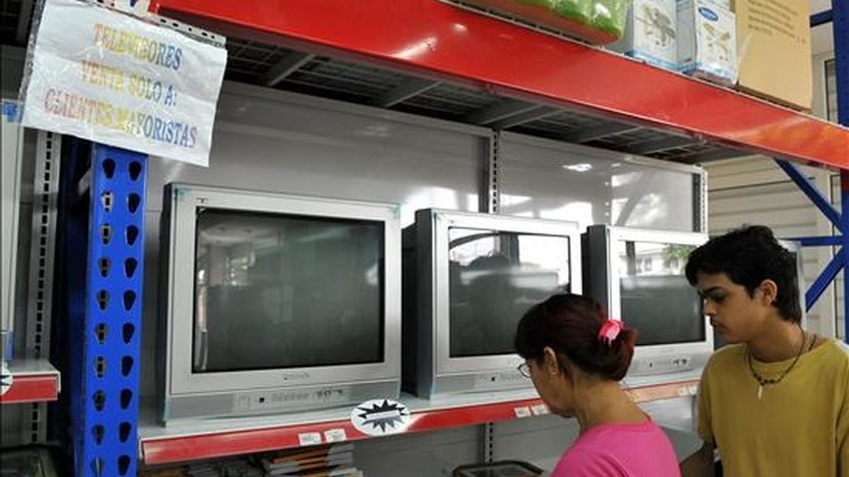 Dos personas miran estantes con televisores en una tienda. EFE/Archivo