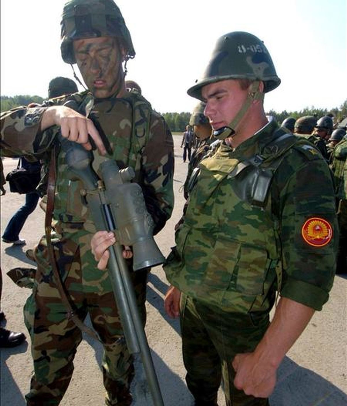Un soldado estadounidense (izqda.) explica a un ruso (dcha.) como funciona un rifle durante las prácticas militares en Grafenwoehr, Alemania, lo 2 de junio de 2005. EFE/Archivo