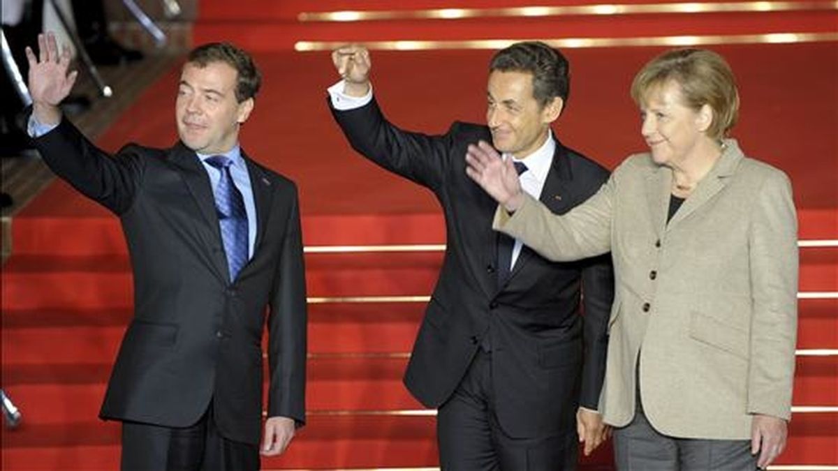 La canciller alemana Angela Merkel, el presidente francés Nicolas Sarkozy (c), y el presidente ruso, Dmitri Medvédev (izda), saludan durante la cumbre tripartita que han celebrado en Deauville, Francia. EFE