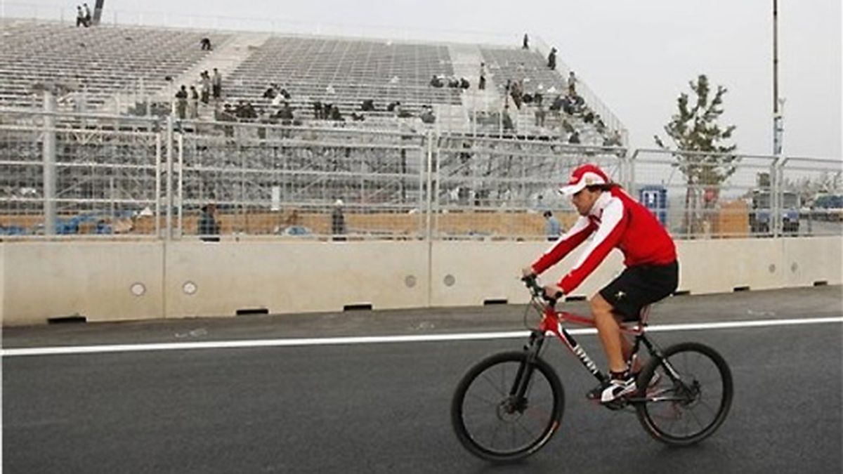 Alonso realiza su tradicional recorrido en bici por el circuito de Corea. FOTO: AP.