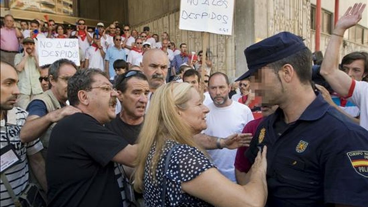 El director de La Semana Negra de Gijón, Paco Ignacio Taibo (i), acompañado de su mujer, trata de calmar a un miembro de la Policía Nacional, durante los incidentes producidos por una manifestación de trabajadores de la empresa Chupa Chups, que han protestado contra el cierre de la fábrica que esta empresa tiene en Asturias. EFE