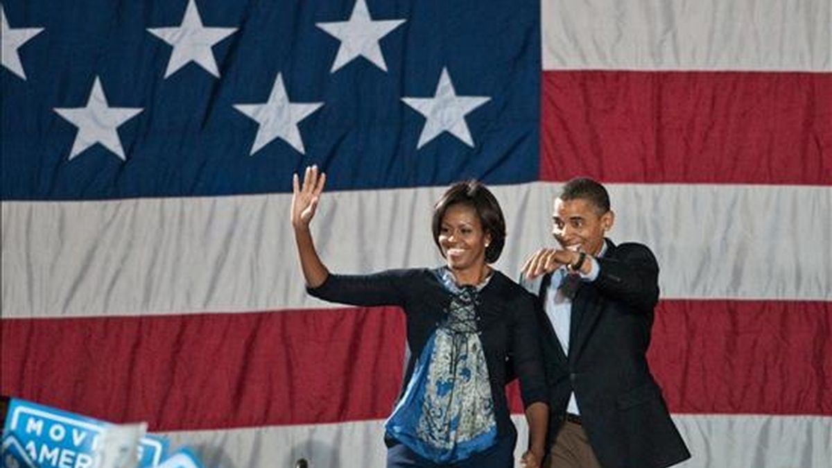 El presidente estadounidense, Barack Obama (d), y su esposa, Michelle Obama (i), saludan a la multitud este domingo en el campus de la Universidad Estatal de Ohio, en Columbus (EE.UU.), como parte de las constantes apariciones del mandatario alrededor del país para impulsar a los candidatos demócratas al Congreso, previo a las elecciones legislativas del próximo 2 de noviembre. EFE