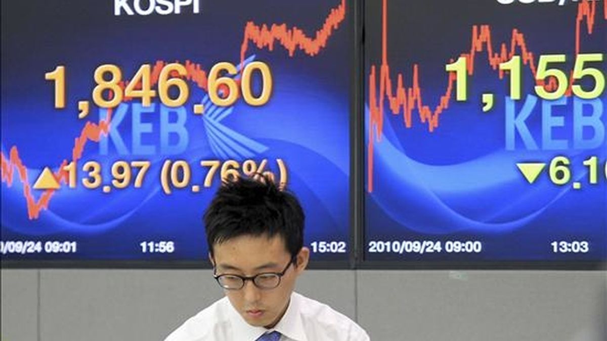 Un agente de bolsa trabaja en el parqué mientras las pantallas reflejan el índice Kospi del mercado surcoreano. EFE/Archivo