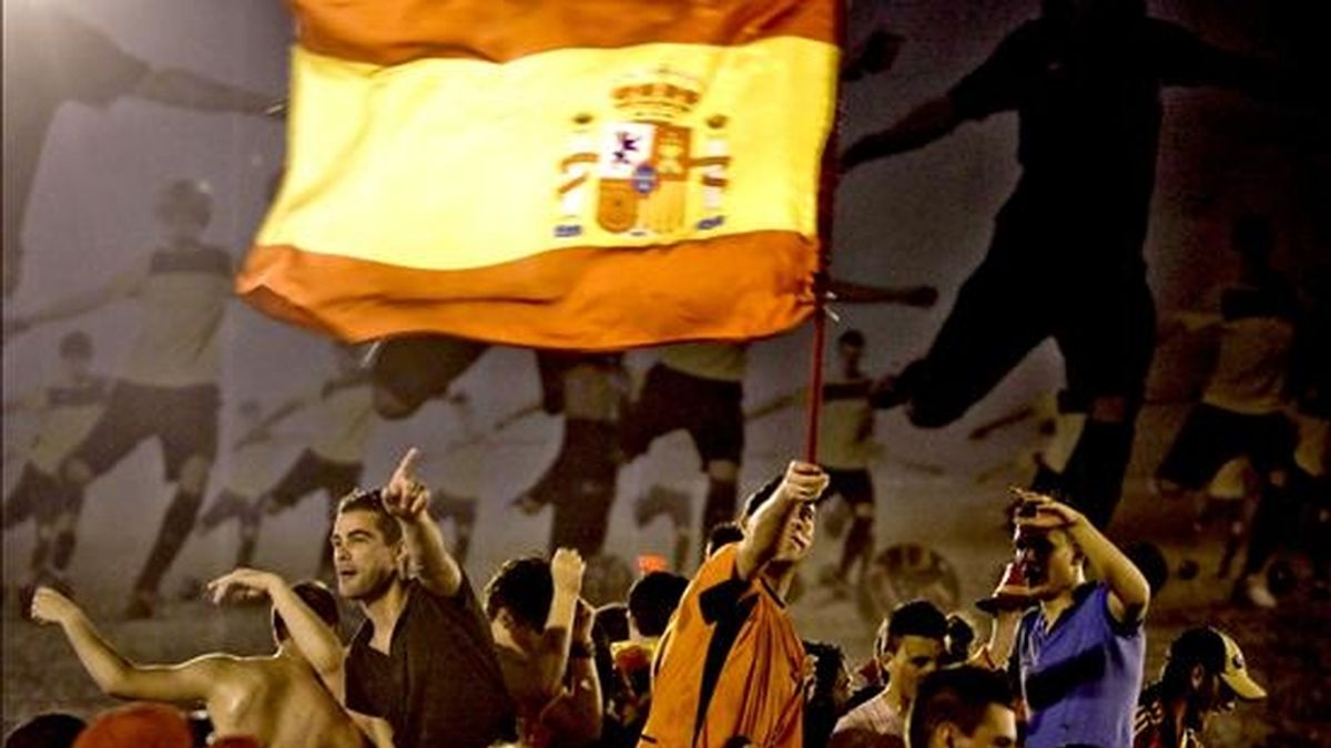 Varios aficionados de la selección española celebran la victoria de su equipo en la plaza de Cibeles de Madrid tras el partido correspondiente a la final del Mundial de Sudáfrica. EFE